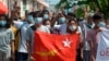 FILE - Protesters hold the flag of the National League for Democracy party of ousted Myanmar leader Aung San Suu Kyi at a rally against the military coup in Yangon, Myanmar, on May 9, 2021. The junta will execute five democracy activists on Sept. 24, 2024, a rights group says.