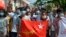 FILE - Protesters hold the flag of the National League for Democracy party of ousted Myanmar leader Aung San Suu Kyi at a rally against the military coup in Yangon, Myanmar, on May 9, 2021. The junta will execute five democracy activists on Sept. 24, 2024, a rights group says.