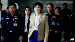 Prime Minister Yingluck Shinawatra, center, leaves the Thai Air Force headquarters after a cabinet meeting in Bangkok, Thailand, Feb. 25, 2014.