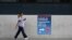 A person walks past a sign for a coronavirus disease assessment clinic in Sydney, Australia, Dec. 10, 2020. 