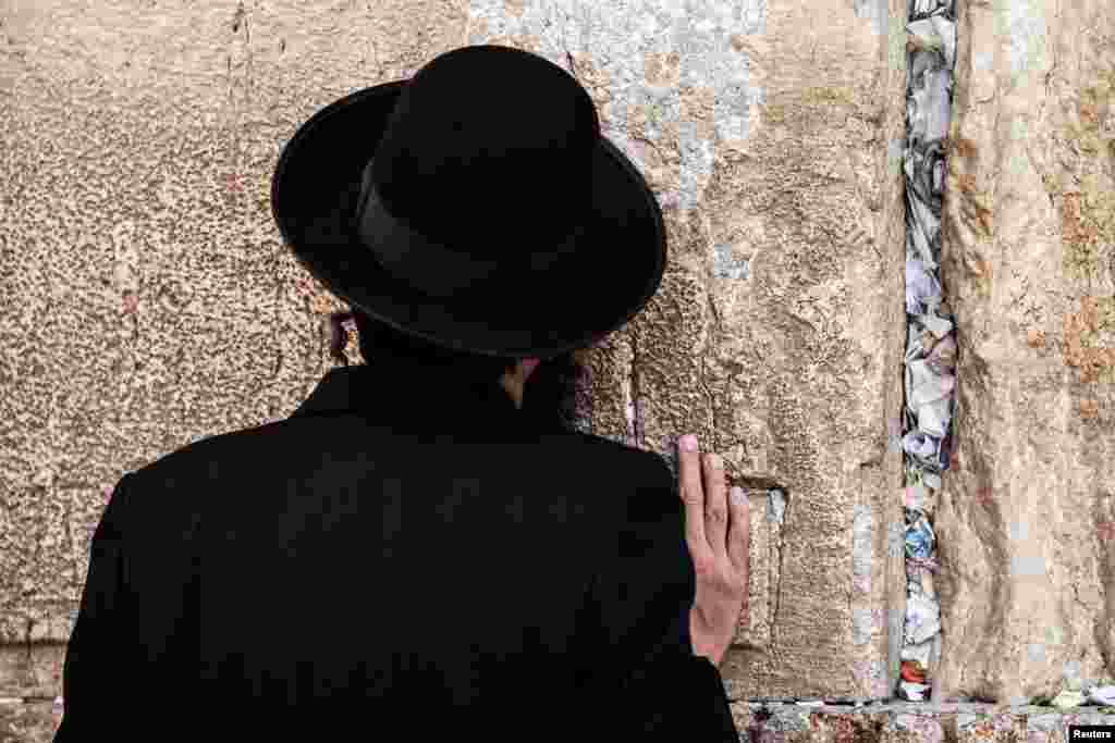 A man prays as notes to God were placed in the cracks of the Western Wall, Judaism&#39;s holiest prayer site, to make space for new notes ahead of the Jewish New Year, in Jerusalem&#39;s Old City.