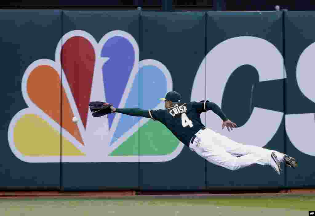 Oakland Athletics left fielder Coco Crisp dives but can't catch a line drive from Houston Astros' Luis Valbuena during the second inning of a baseball game, July 18, 2016, in Oakland, Calif. 