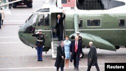 Former U.S. President Barack Obama waves as newly sworn-in President Donald Trump walks with wife Melania Trump, on Capitol Hill in Washington, D.C., Jan. 20, 2017.