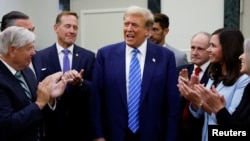 โดนัลด์ ทรัมป์ (กลาง) ท่ามกลางการปรบมือของสมาชิกพรรครีพับลิกันที่สำนักงานใหญ่คณะกรรมการวุฒิสภาพรรครีพับลิกันแห่งชาติ (NRSC) ในกรุงวอชิงตัน วันที่ 13 มิถุนายน 2024 (ที่มา: รอยเตอร์)