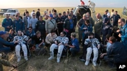 Astronot Terry Virts (kiri), Anton Shkaplerov, dan Samantha Cristoforetti beristirahat dan menelepon keluarganya setelah mendarat dengan selamat di Dzhezkazgan, Kazakhstan, Kamis (11/6).