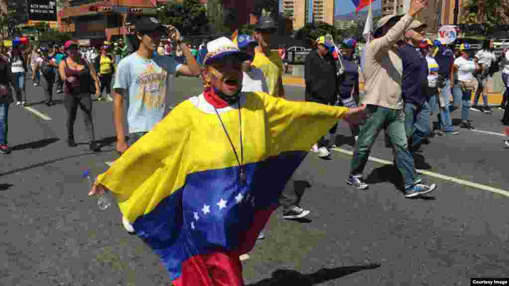 Una venezolana porta la bandera de Venezuela durante marcha por la ayuda humanitaria, el martes.&nbsp;