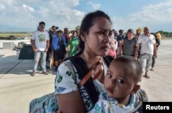 People injured or affected by the earthquake and tsunami wait to be evacuated on an air force plane in Palu, Central Sulawesi, Indonesia, Sept. 30, 2018.