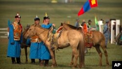 Mongolian horsemen in traditional outfits stand with their mounts before a horse racing competition during the second day of the Naadam Festival in Khui Doloon Khudag, on the outskirts of Ulaanbaatar, Mongolia, July 12, 2016. 