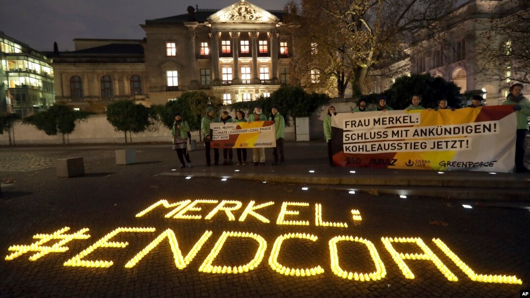 Un mensaje con 1.200 velas que dice 'Merkel pon fin al carbón' fue colocado por activistas del medio ambiente frente a un edificio frente al parlamento federal en Berlín, donde la canciller Angela Merkel y otros políticos se reúnen para hablar sobre una posible coalición política de 4 partidos que incluiría al Partido Verde. Noviembre 14, 2017.