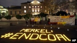 Un mensaje con 1.200 velas que dice 'Merkel pon fin al carbón' fue colocado por activistas del medio ambiente frente a un edificio frente al parlamento federal en Berlín, donde la canciller Angela Merkel y otros políticos se reúnen para hablar sobre una posible coalición política de 4 partidos que incluiría al Partido Verde. Noviembre 14, 2017.