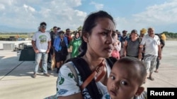 Warga yang luka-luka akibat gempa dan tsunami menunggu untuk dievakuasi dengan pesawat di Palu, Sulawesi Tengah, 30 September 2018. (Antara Foto/Muhammad Adimaja via REUTERS)