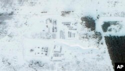 This satellite image provided by Planet Labs PBC shows vehicles and tanks stationed at the Pogonovo training area just south of the city of Voronezh, Russia, Jan. 26, 2022.