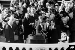 FILE - Former Vice President Richard Nixon shakes hands with President John F. Kennedy at the end of Kennedy's inauguration, in Washington, June 20, 1961. (AP Photo, File)