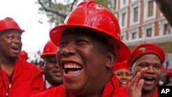 FILE - Julius Malema, center, leader of the Economic Freedom Fighters (EFF), arrives at Parliament wearing a hard hat and overall to show solidarity with coal mine workers, in Cape Town, South Africa, May 21, 2014.