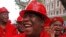 FILE - Julius Malema, center, leader of the Economic Freedom Fighters (EFF), arrives at Parliament wearing a hard hat and overall to show solidarity with coal mine workers, in Cape Town, South Africa, May 21, 2014.