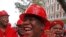 FILE - Julius Malema, center, leader of the Economic Freedom Fighters (EFF), arrives at Parliament wearing a hard hat and overall to show solidarity with coal mine workers, in Cape Town, South Africa, May 21, 2014.