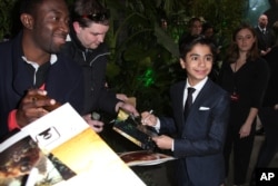 Actor Neel Sethi, who plays the character Mowgli, signs autographs upon arrival at the premiere of the film "The Jungle Book" in London, April 13, 2016.