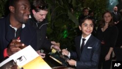 Actor Neel Sethi, who plays the character Mowgli, signs autographs upon arrival at the premiere of the film "The Jungle Book" in London, April 13, 2016. 