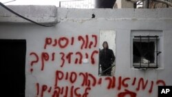 Palestinians visit vandalized mosque in the Arab neighborhood of Beit Safafa, in east Jerusalem, Jan. 24, 2020.