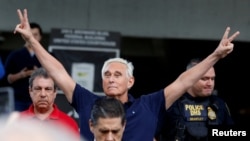 FILE - Long-time friend of President Donald Trump Roger Stone flashes victory signs after his appearance at Federal Court in Fort Lauderdale, Florida, Jan. 25, 2019.