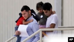 FILE - Immigrant families leave a United States Immigration and Customs Enforcement facility after they were reunited in San Antonio, July 11, 2018.