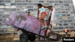 Fabiana Silva, 38, a former crack user who now collects recyclable materials, jumps off her cart loaded with recyclables in Sao Paulo, Brazil, June 29, 2017.