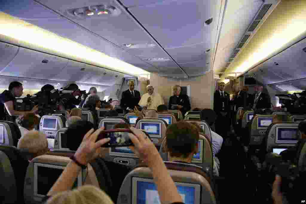 Paus Fransiskus berbicara pada media selama konferensi pers di atas pesawat dalam perjalannya ke Roma dari Seoul, Korea Selatan (18/8). (AP/Gregorio Borgia)