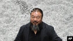 Chinese artist Ai Weiwei poses with some seeds from his art installation 'Sunflower Seeds' in London, Monday, Oct. 11, 2010. The specially commissioned art piece takes the form of a field of sunflower seeds inside the Turbine Hall at Tate Modern gallery, 