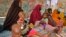 FILE - In this photo taken March 25, 2017, Somali women and their malnourished children attend a health center in Baidoa, Somalia. 