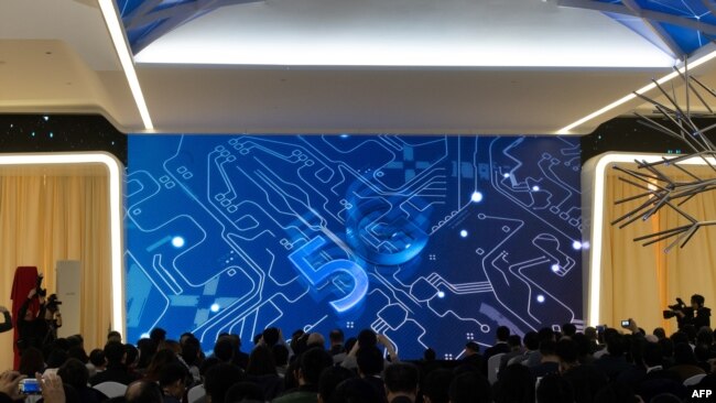 记者和宾客在华为公司在北京的新闻中心观看介绍华为推出5G新产品的短片。(2019年1月24日)