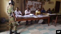 A Congo soldier (l) prepares to cast his ballot, at a polling station, in Brazzaville, Congo, March 20, 2016.