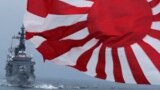 FILE - Japan Maritime Self-Defense Force (JMSDF) escort ship "Kurama," left, navigates behind destroyer "Yudachi," with a flag, during a fleet review in water off Sagami Bay, south of Tokyo.