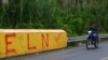 FILE - A motorcycle passes by a sign that reads "ELN" that refers to the National Liberation Army guerrilla group in Corinto, Valle del Cauca province, Colombia, June 6, 2024. The ELN announced a unilateral truce on Dec. 22, 2024, to last until Jan. 3, 2025.