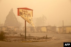 The melted sign of the Oak Park Motel destroyed by the flames of the Beachie Creek Fire is seen in Gates, east of Salem, Oregon on September 13, 2020.