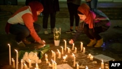 People stand by as a makeshift memorial is made after vigil at the University of North Carolina following the murders of three Muslim students, in Chapel Hill, North Carolina, Feb. 11, 2015.