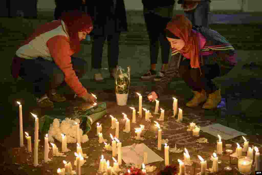 People stand by as a makeshift memorial is made after vigil at the University of North Carolina following the murders of three Muslim students, in Chapel Hill, North Carolina, Feb. 11, 2015.