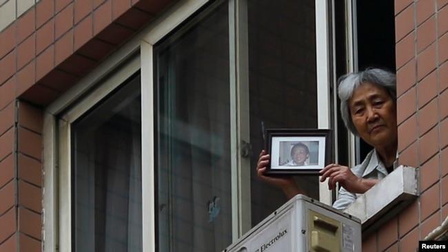 资料照：“天安门母亲群体”其中代表人物张先玲在住宅窗口展示八九六四在天安门被军队杀死的儿子的照片。