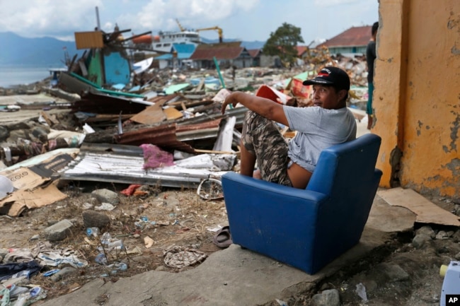 A man sits on a chair in the shell of a house heavily damaged by the tsunami in Wani village on the outskirts of Palu, Central Sulawesi, Indonesia, Oct. 4, 2018.