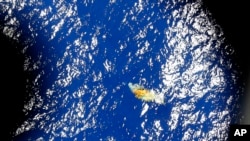 An image taken onboard a Royal New Zealand P-3 Orion shows a piece of unknown debris floating just under the water while the plane was searching for missing Malaysia Airlines Flight MH370 in the southern Indian Ocean, Australia, March 31, 2014.