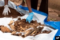 FILE—Remains of victims are retrieved from a site, in Huye District, southern Rwanda, January 23, 2024.