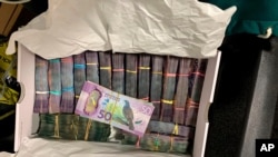 In this undated photo supplied by the New Zealand police, a box containing a large amounts of cash is seen after being discovered during a police raid as part of Operation Trojan. Authorities in Australia and New Zealand, June 8, 2021.