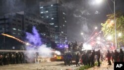 Polisi anti huru-hara menembakkan gas air mata dalam aksi demonstrasi mahasiswa di luar gedung DPR/MPR di Senayan, Jakarta, Selasa (24/9).