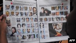 A man reads a newspaper with portraits of Westgate mall victims as Kenya commemorates the first anniversary since the terror attack that happened in the Nairobi's shopping mall, Sept. 19, 2014. 