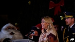 Bolivia's interim President Jeanine Anez, center, speaks during the Christmas tree lighting ceremony at the Murillo square in La Paz, Bolivia, Dec. 9, 2019. 