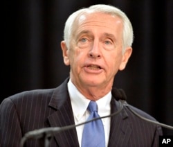 FILE - Kentucky Governor Steve Beshear speaks to the media and a group of Ford employees at the Kentucky Truck Plant in Louisville, Dec. 1, 2015.