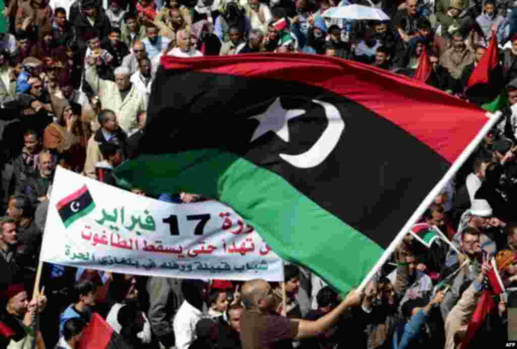 Anti-Libyan leader Moammar Gadhafi protesters, wave the pre-Gadhafi Libyan flag during a protest after Friday prayers at Court Square, in Benghazi, eastern Libya, Friday March 11, 2011. French President Nicolas Sarkozy faced increasing pressure from fello