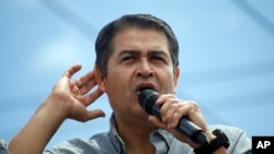 FILE - Honduran President Juan Orlando Hernandez listens to the crowd as he delivers a speech during a rally in Tegucigalpa, June 22, 2019. 