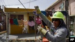 Ezequiel Rivera works with the Electric Energy Authority to restore distribution lines damaged by Hurricane Maria in the Cantera community of San Juan, Puerto Rico, Oct. 19, 2017.