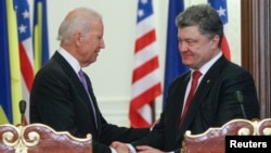 FILE - U.S. Vice President Joe Biden (L) shakes hands with Ukraine's President Petro Poroshenko during a news conference in Kyiv, November 2014. 