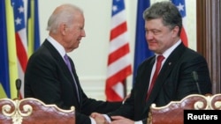 U.S. Vice President Joe Biden (L) shakes hands with Ukraine's President Petro Poroshenko during a news conference in Kyiv, Nov. 21, 2014. 